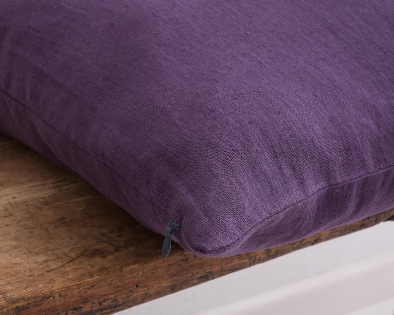 Close up of a deocorative square pillow cover, in the color dark violet showcasing the hidden zipper closure.
