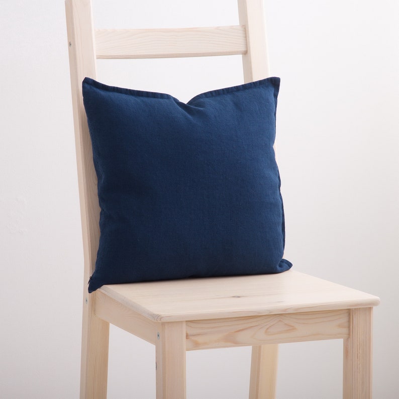 Navy blue linen pillow case on a chair.