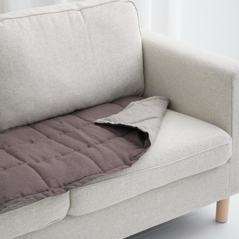 Close-up of sofa seat pad made from natural linen, featuring quilted stitching, perfect for sectional couches or single seats, pet-friendly and stylish.