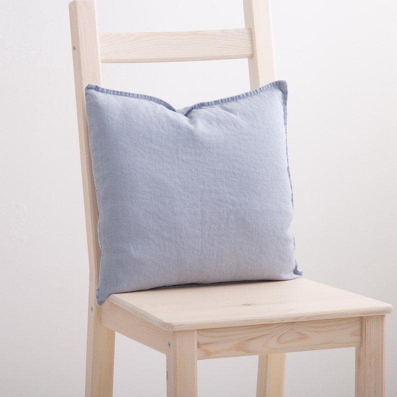 Gray-blue linen pillow case on a chair.