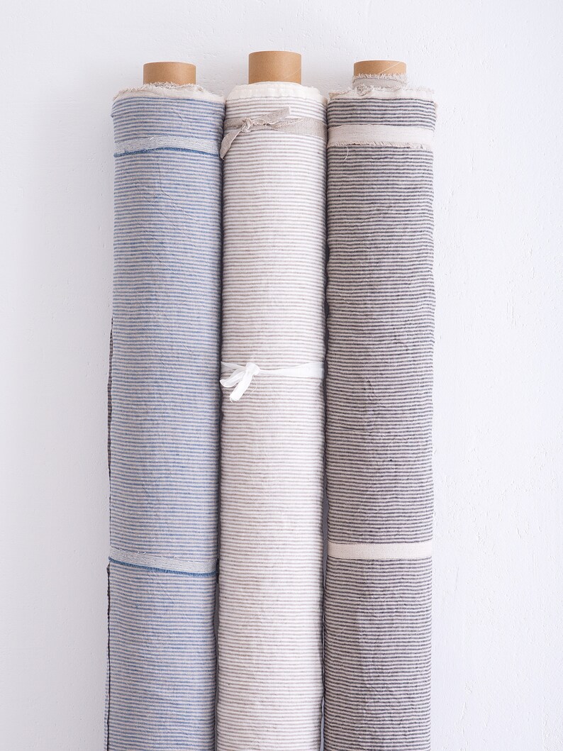May include: Three rolls of striped fabric, one blue and white, one beige and white, and one gray and white.
