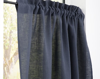 May include: Dark navy blue linen window curtain panel. The curtain is gathered at the top and hangs in soft folds. The curtain is hanging on a black rod in front of a window with a blurred outdoor view.