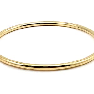 Może przedstawiać: Prosta złota bransoletka. Bransoletka jest gładka i błyszcząca.