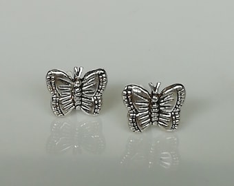 Op de afbeelding: Een paar zilveren vlinder oorbel studs. De vlinders hebben gedetailleerde vleugels en een textuur.