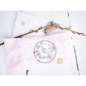 May include: A pink and white striped pillow with a white lace trim. The pillow has a circular patch with a drawing of a fairy with wings and a wand. The text on the patch reads "Steffi's Stick Staff".