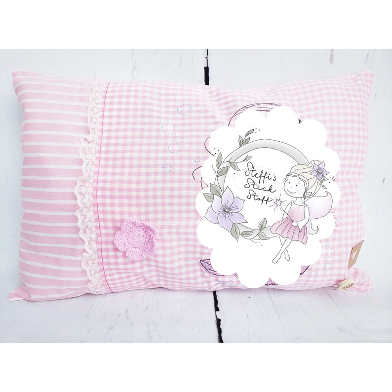 May include: Pink and white striped pillow with a gingham pattern and a white circle with a fairy illustration and the text "Steffi's Stick Staff".