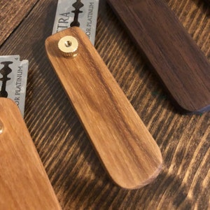 May include: A wooden razor handle with a gold-colored knob and a razor blade that says "Extra Superior Platinum".