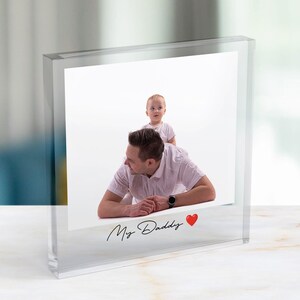 Może przedstawiać: Przezroczysty akrylowy blok fotograficzny ze zdjęciem mężczyzny i dziecka. Mężczyzna leży, a dziecko jest na jego plecach. Tekst "My Daddy" jest napisany kursywą z czerwonym sercem.