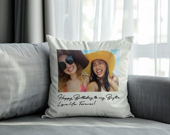 May include: A square white throw pillow featuring a centred rectangular photograph of two smiling individuals wearing sun hats and sunglasses. Below the image, the black cursive text reads: Happy Birthday to my Bestie, Love Ya Forever!