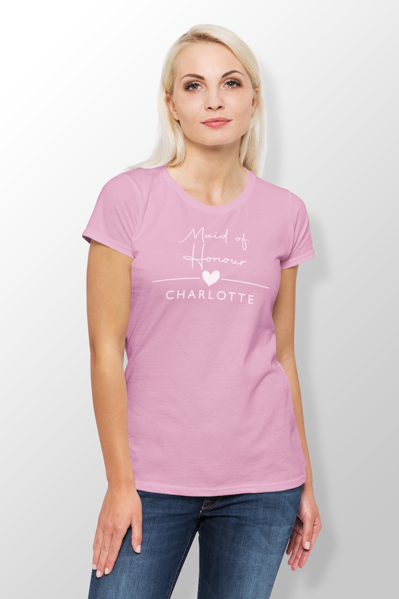 A woman wearing a pink t-shirt with the text "Maid of Honor Charlotte" printed on it.