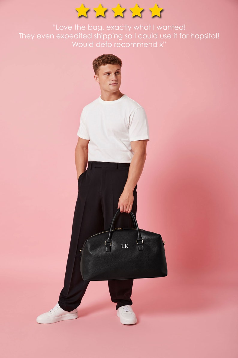 May include: A black leather travel bag with gold hardware and the initials "LR" embroidered on the front. The bag is being held by a person wearing a white t-shirt and black pants.
