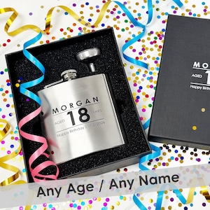 May include: A silver-toned metal flask with a matching funnel inside a black gift box. The flask is engraved with the name MORGAN, the text AGED 18 YEARS, and Happy Birthday 01/02/2026. The box lid features the text MORGAN AGED 18 Happy Birthday.