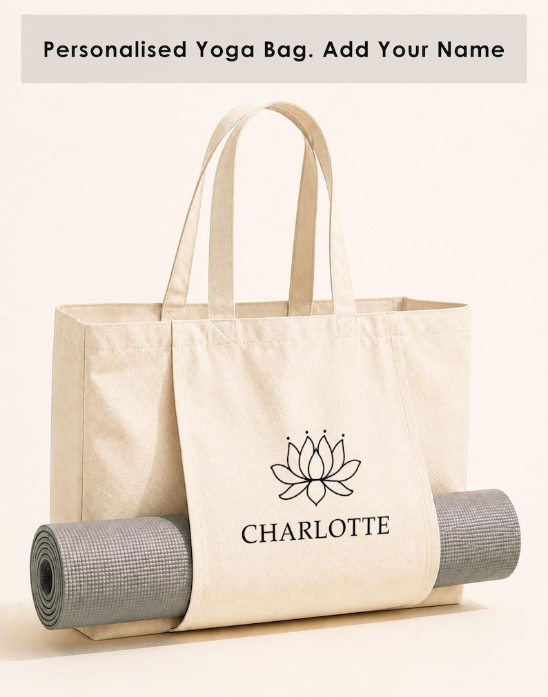 A beige canvas tote bag with a printed logo and the name "CHARLOTTE" printed on it, along with a gray yoga mat rolled up inside the bag.