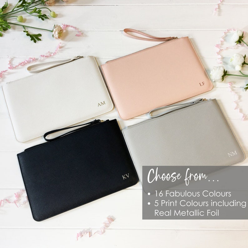 May include: Four different colored zippered pouches with personalized initials. The pouches are white, pink, gray, and black. The text "Choose from... 16 Fabulous Colours 5 Print Colours including Real Metallic Foil" is displayed below the pouches.