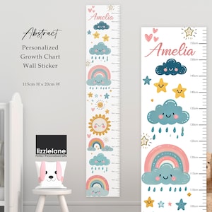 Pode incluir: Adesivo de parede personalizado para gráfico de crescimento com um design lúdico com arco-íris, nuvens, estrelas e um sol sorridente. O gráfico tem 115 cm de altura e 20 cm de largura, com o nome "Amelia" no topo.