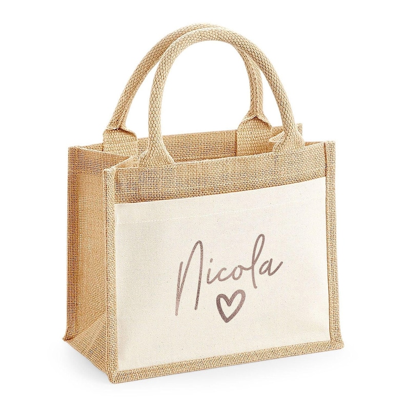 A beige tote bag with a name printed on it.