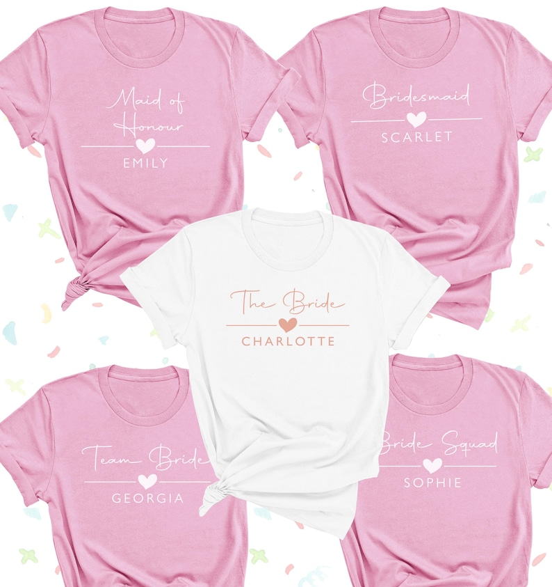 a collection of pink t-shirts with various names and titles printed on them, including "Maid of Honor", "Emilly", "Bridal Squad", "Team Bride", and "Charlotte".
