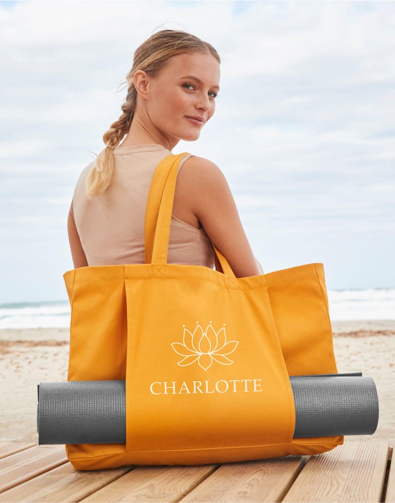 A woman sits on a wooden bench, holding a large orange tote bag with the word "CHARLOTTE" printed on it.