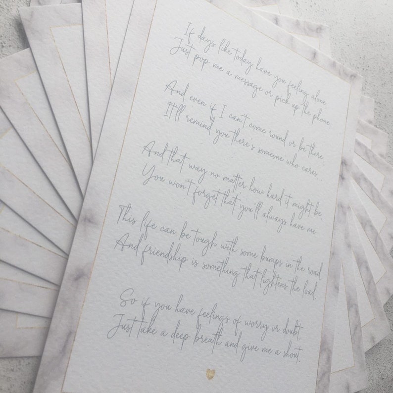 May include: A white card with a handwritten message about friendship. The card has a marble-like background and gold accents. The text reads: "If days like today have you feeling alone, just pop me a message or pick up the phone. And even if I can't come round or be there, I'll remind you there's someone who cares. And that way no matter how hard it might be, you won't forget that you'll always have me. This life can be tough with some bumps in the road, and friendship is something that lightens the load. So if you have feelings of worry or doubt, just take a deep breath and give me a shout."
