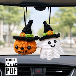 Op de afbeelding: Twee hangende gehaakte ornamenten met een ronde oranje pompoen en een witte geest, beide met zwarte puntmutsen met groene banden en oranje gespen. De items hebben zwarte kraaloogjes en geborduurde glimlachen. Tekst leest CROCHET PATTERN PDF.