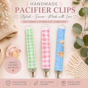 Puede incluir: Tres clips de tela para chupetes con enganches metálicos. Un clip presenta un patrón de cuadros vichy verde y blanco, otro un patrón de cuadros rosa y blanco, y el tercero es azul claro con una ilustración de un oso marrón. Incluye un chupete rosa.