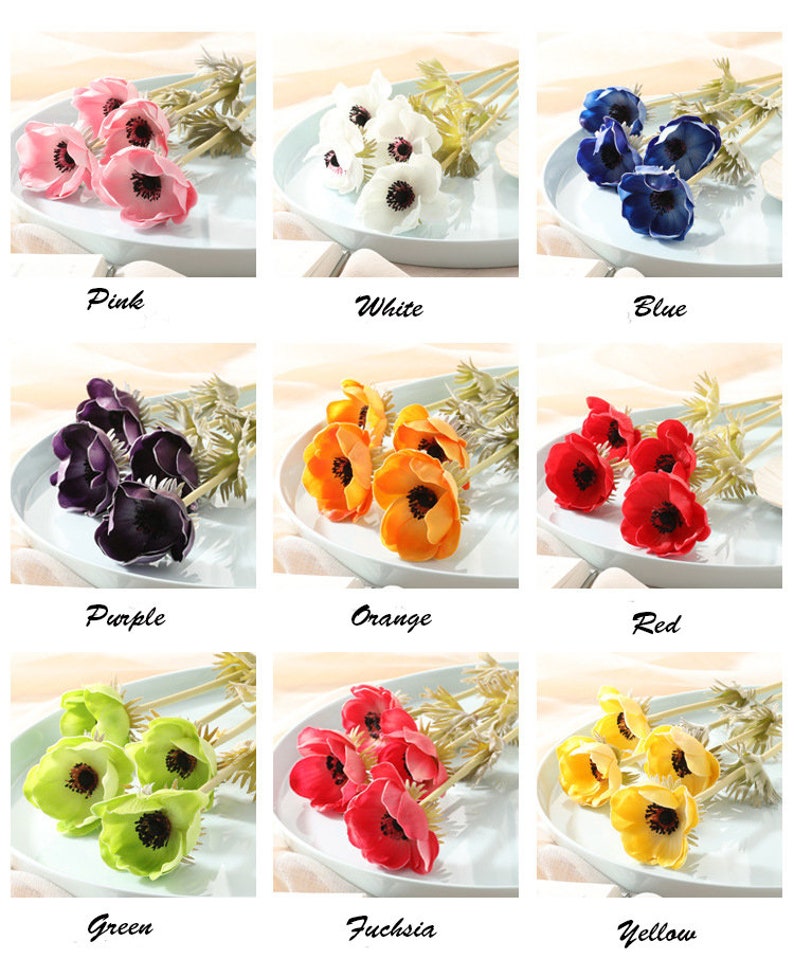 May include: A set of 10 artificial anemone flower stems in various colors, including pink, white, blue, purple, orange, red, green, fuchsia, yellow. The flowers are arranged in a bouquet on a white plate.