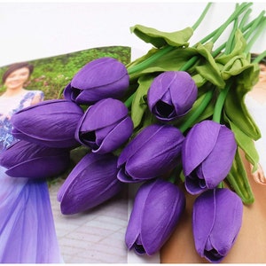 May include: A bouquet of ten purple artificial tulips with green stems and leaves.