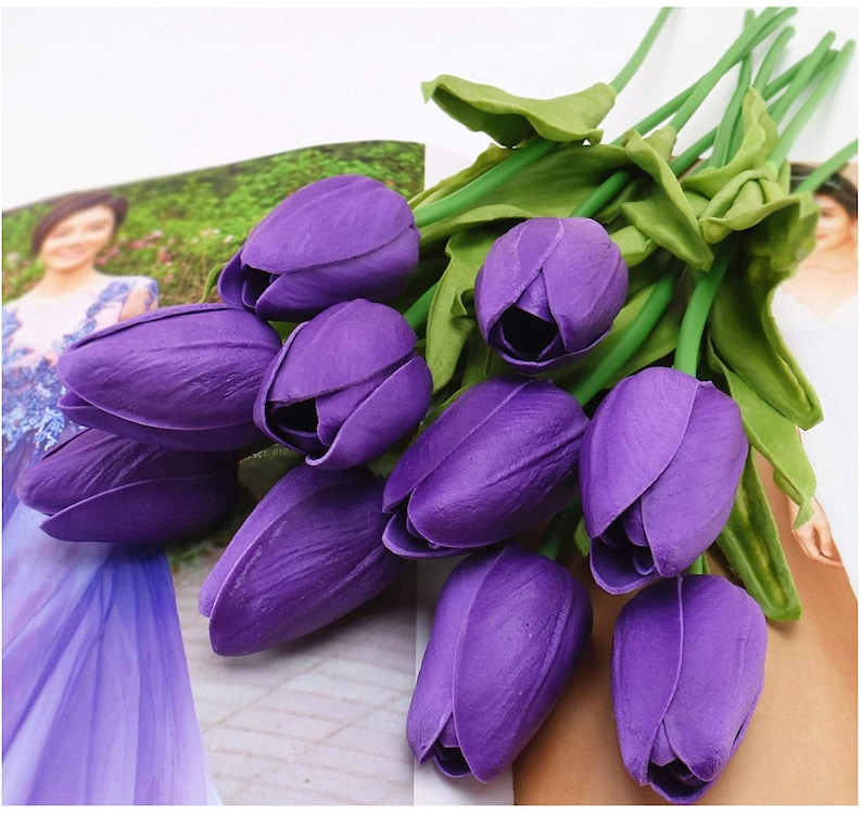 May include: A bouquet of ten purple artificial tulips with green stems and leaves.