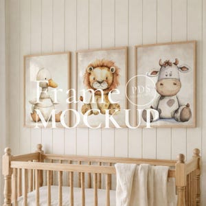 May include: Three framed watercolour prints of a duck, lion, and cow. The artwork has a soft, neutral colour palette with a light beige background. The frames are a light wood colour, and the overall theme is a nursery or children's room.