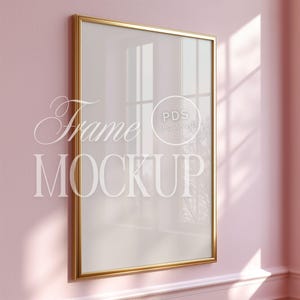 May include: A gold-colored frame with a white mat and a clear glass insert. The frame is hanging on a pink wall. The text "Frame Mockup" is visible in the image.