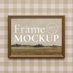 Puede incluir: Un marco dorado rectangular con una maqueta de pintura de paisaje. La pintura presenta un campo con árboles y un cielo nublado. El texto blanco dice "Frame MOCKUP". El fondo es un patrón de cuadros beige y blanco.