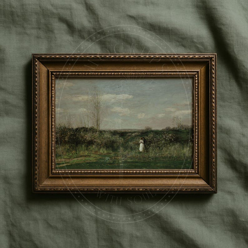 May include: A framed landscape painting depicting a tranquil outdoor scene. The artwork shows a figure in a white dress in a field, with trees and a cloudy sky. The frame is made of dark, ornate wood.