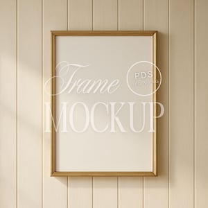 Może przedstawiać: Prostokątny złoty makieta ramki z napisem "Frame Mockup" w białym skrypcie. Ramka jest wyśrodkowana na jasnobeżowym tle z pionowych paneli drewnianych. Ramka ma białe wnętrze.