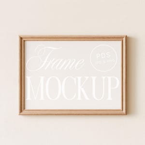 May include: A rectangular wooden frame with a light beige background. The words "Frame MOCKUP" are displayed in white, with a circular logo that says "PDS JPG & PNG". The frame is made of light brown wood.