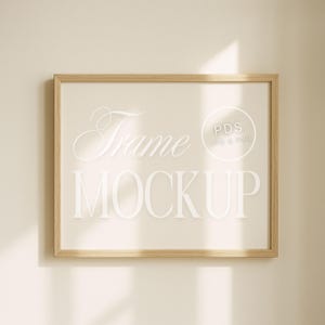 Könnte beinhalten: Ein rechteckiger Holzrahmen-Mockup mit den Worten "Frame MOCKUP" in einer weißen, eleganten Schriftart. Der Rahmen hängt an einer beigefarbenen Wand. Das Bild enthält auch den Text "PDS JPG & PNG" in einem Kreis.