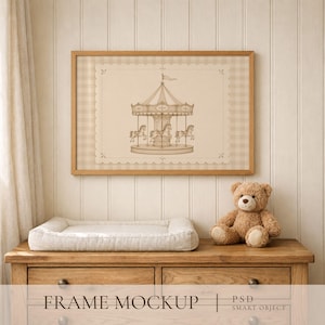 May include: A rectangular wooden frame containing a beige print of a carousel with horses, set against a light checkered background. The frame is displayed above a white changing pad and a brown teddy bear on a wooden dresser with drawers.