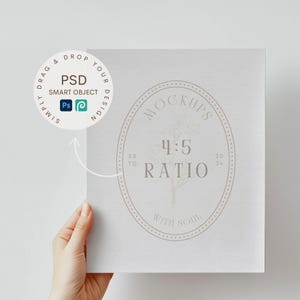 May include: A white card mockup with a grey circle design. The circle has the text "MOCKUPS 4:5 RATIO WITH SOUL" inside. The card is being held by a hand.
