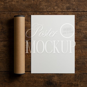 Pu&ograve; includere: Un mockup di poster bianco arrotolato in un tubo marrone su una superficie di legno. Il poster ha il testo "Poster Mockup" e un logo che dice "PDS JPG & PNG".