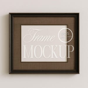 Könnte beinhalten: Ein brauner Holzbilderrahmen mit einem weißen Passepartout und einem weißen Hintergrund. Der Rahmen hat ein schlichtes Design und ist perfekt zum Anzeigen von Fotos oder Kunstwerken. Der Text "Frame Mockup" ist in der Mitte des Rahmens sichtbar.