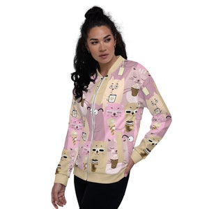 May include: A pink and beige bomber jacket with a repeating pattern of cartoon cats drinking coffee and eating ice cream cones.