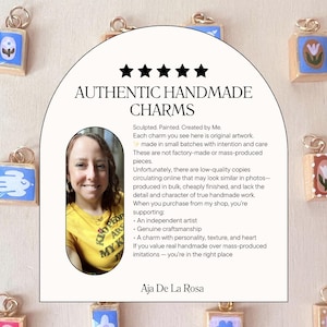 May include: A collection of small, square, hand-painted charms with gold-toned jump rings, arranged around a central arch-shaped sign. The sign features five black stars, the text AUTHENTIC HANDMADE CHARMS, a portrait of an artist, and descriptive text.