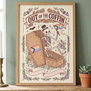 May include: A framed art print featuring a skeleton wearing a top hat and a rainbow sash, emerging from a wooden coffin. The skeleton holds a rainbow flag. The text reads "OUT of the COFFIN" above the coffin, surrounded by bats, flowers, and stars.