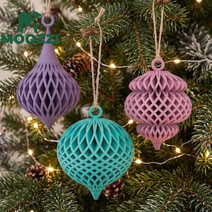 Può includere: Tre decorazioni sospese stampate in 3D con intricati motivi a reticolo. Una è viola chiaro a forma di goccia, una è verde acqua di forma arrotondata e una è color rosa antico con un design bulboso a più livelli.