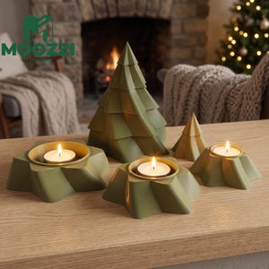 Puede incluir: Un conjunto de objetos decorativos geométricos de color verde oliva que incluye un gran árbol de Navidad estilizado, un árbol más pequeño y tres portavelas en forma de estrella. Cada portavelas contiene una vela blanca encendida.