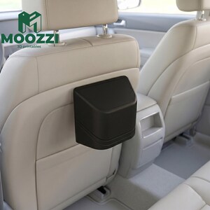 May include: A black car trash can attached to the back of a car seat. The trash can is a small, angled box with a lid. The logo "MOOZZI 3D printables" is visible in the background.