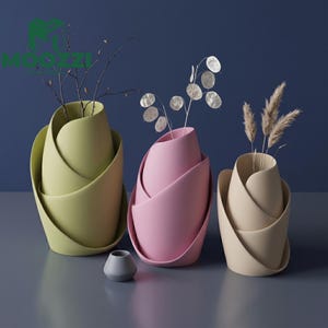 Può includere: Tre vasi moderni a forma di tulipano nei colori pastello: verde chiaro, rosa e beige. Ogni vaso contiene steli decorativi secchi. Un piccolo vaso grigio è davanti. Lo sfondo è blu scuro.