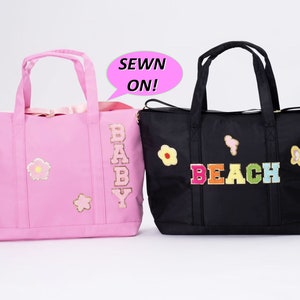 May include: Two tote bags, one pink and one black, with colorful patches sewn on. The pink bag has a "BABY" patch and the black bag has a "BEACH" patch. The bags have a sewn-on patch that says "SEWN ON!"