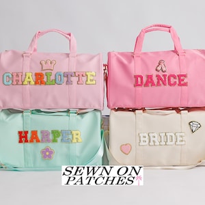 May include: Four duffel bags in pink, mint green, and cream colors. The pink bag has "CHARLOTTE" in colorful letters and a crown. The second pink bag says "DANCE" with a ballet shoe. The mint green bag says "HARPER" with a flower. The cream bag says "BRIDE" with a diamond and heart.