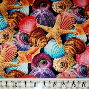 Pode incluir: Um tecido colorido com um padrão repetitivo de conchas, estrelas do mar e ouriços do mar. As conchas são em tons de rosa, azul, marrom e roxo. As estrelas do mar são amarelas e os ouriços do mar são roxos.
