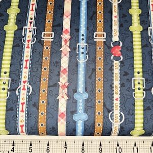 Könnte beinhalten: Stoff mit einem sich wiederholenden Muster von Hundehalsbändern in verschiedenen Farben, darunter Braun, Grün und Blau, auf einem marineblauen Hintergrund. Die Halsbänder haben Herz- und Knochenakzente mit den Worten "LIVE LOVE WOOF".